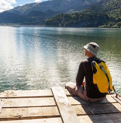 ©Galyna Andrushko – ingimage.com
Mann sitzt mit Rücksack am See ©Galyna Andrushko – ingimage.com