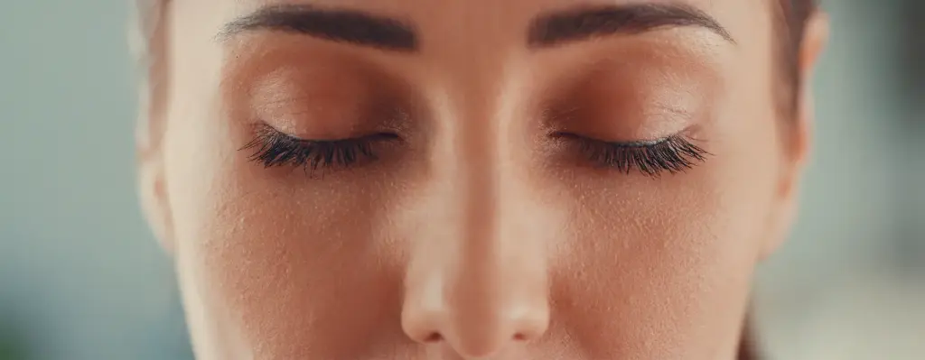 Nahaufnahme des Gesichts einer jungen Frau mit geschlossenen Augen – ruhiger, meditativer Gesichtsausdruck.