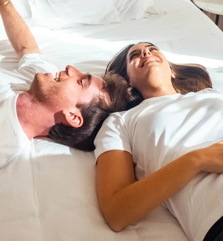 Ein Paar liegt auf einem Bett. Das Bild wird im Bereich "Empfängnisregelung und Empfängnisverhütung" verwendet.