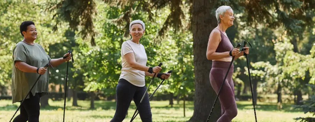 Zwei ältere Damen in Sportkleidung walken durch einen Park. Das Bild wird im Bereich "fit for well Tage" verwendet.
