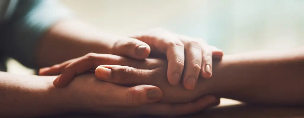Das Bild zeigt eine Nahaufnahme zweier Hände, die sich umschlossen haben. Es wird im Bereich "Hospiz" verwendet.