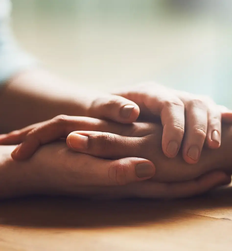 Das Bild zeigt eine Nahaufnahme zweier Hände, die sich umschlossen haben. Es wird im Bereich "Hospiz" verwendet.