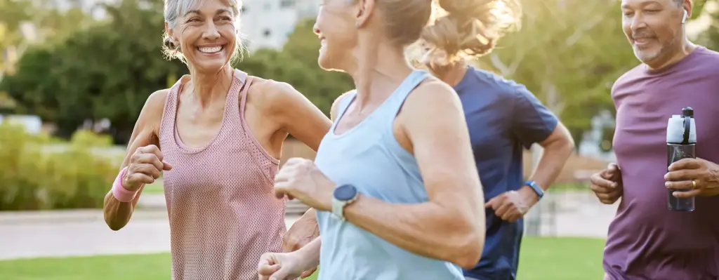 Eine Gruppe von 4 Personen mittleren Alters joggen gemeinsam. Zwei Frauen laufen vorab, zwei Männer folge. Die beiden Frauen blicken sich an. Das Bild wird im Bereich "ProHerz" verwendet.