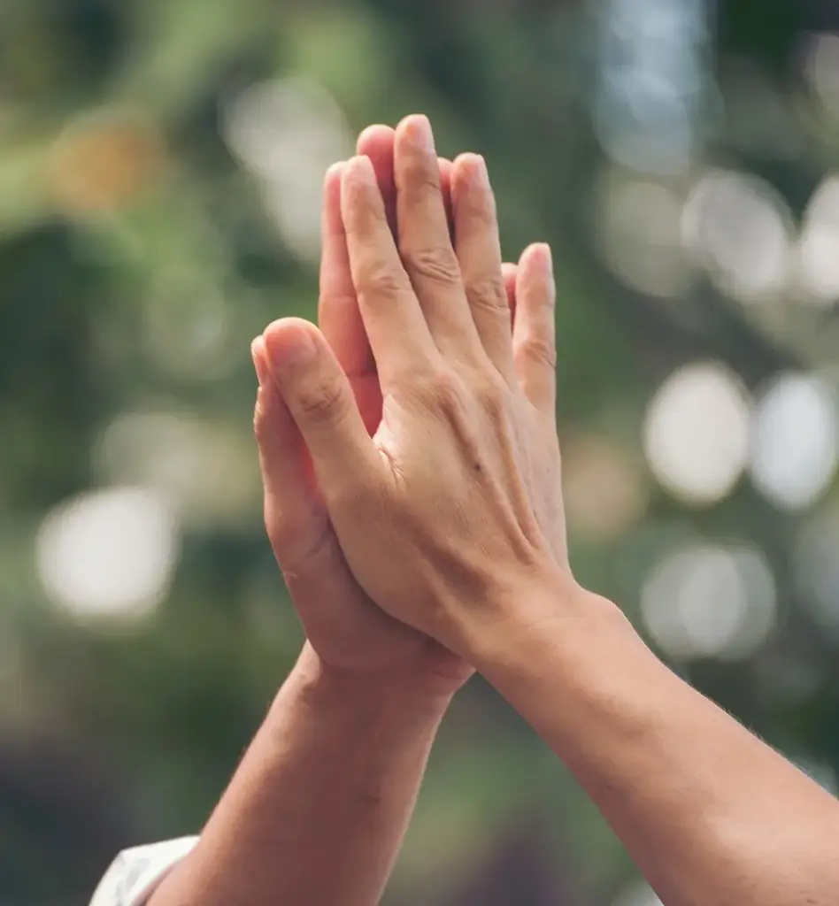 Zwei Hände berühren sich und geben ein High Five.
