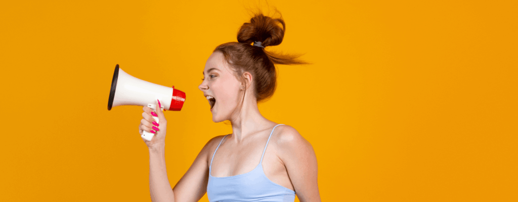 Hochspringende Frau spricht in Megaphon