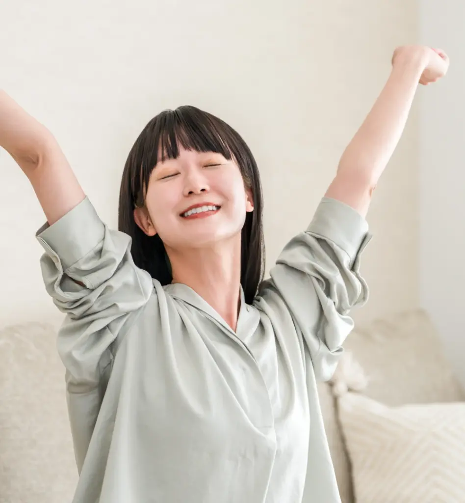 Eine Frau sitzt auf dem Sofa und streckt sich