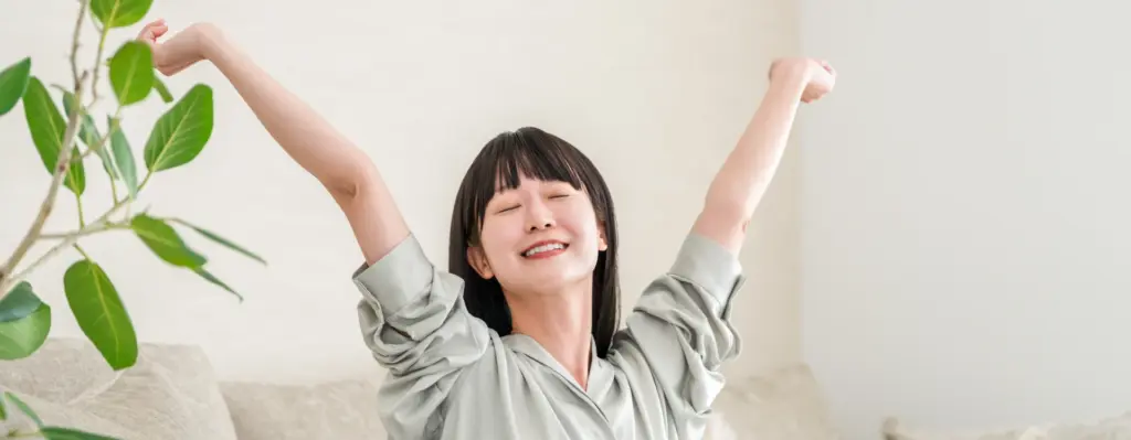 Eine Frau sitzt auf dem Sofa und streckt sich