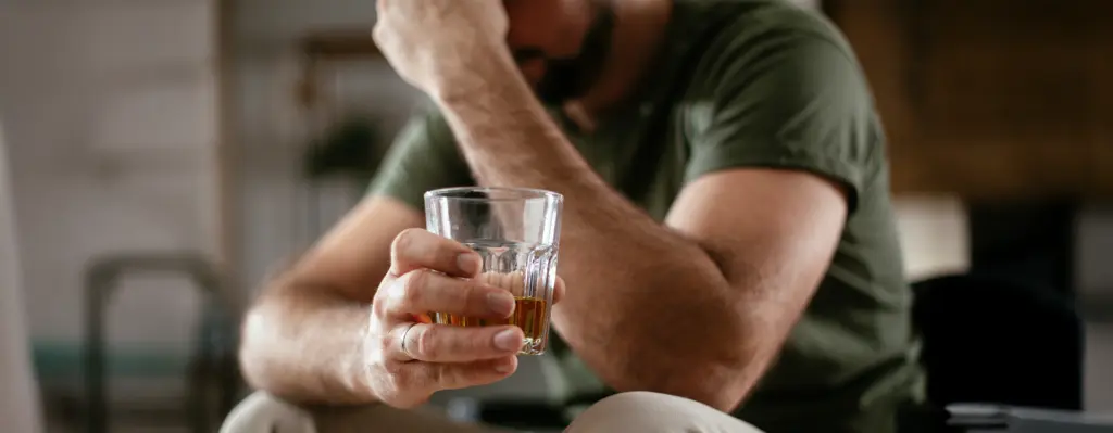 Ein Mann hält ein Whiskeyglas in der Hand