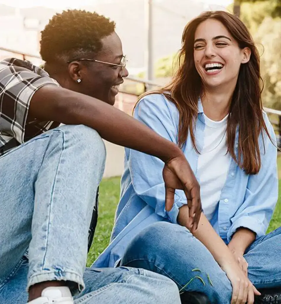 Eine Gruppe junger Leute sitzt auf der Wiese und unterhält sich