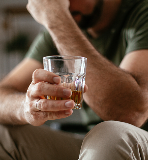 Ein Mann hält ein Whiskeyglas in der Hand
