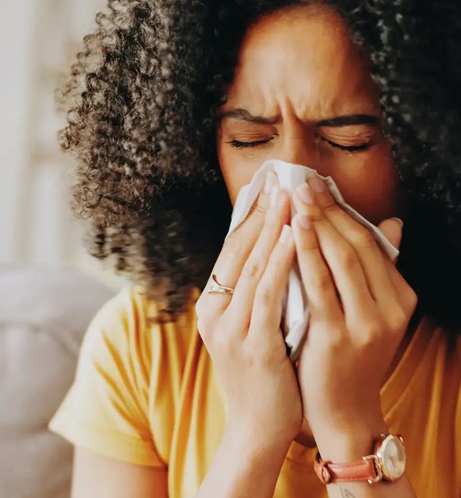 Frau putzt sich die Nase