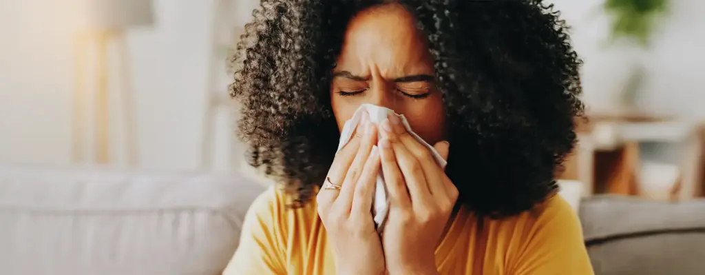 Frau putzt sich die Nase