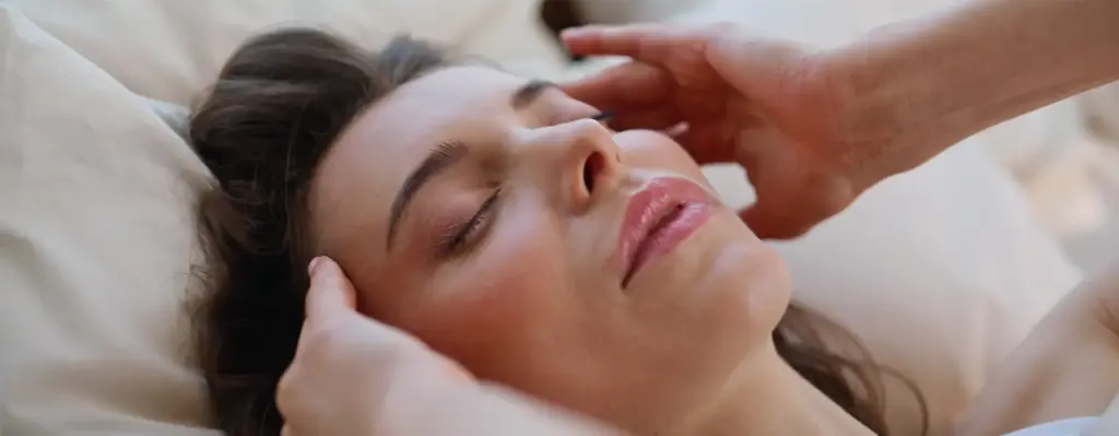 Zu sehen ist eine Frau mit Kopfschmerzen