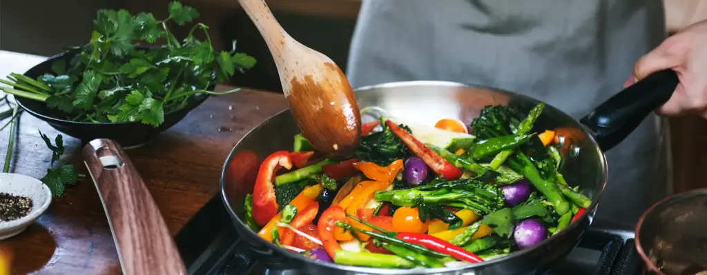 In einer Pfanne wird buntes Gemüse angebraten