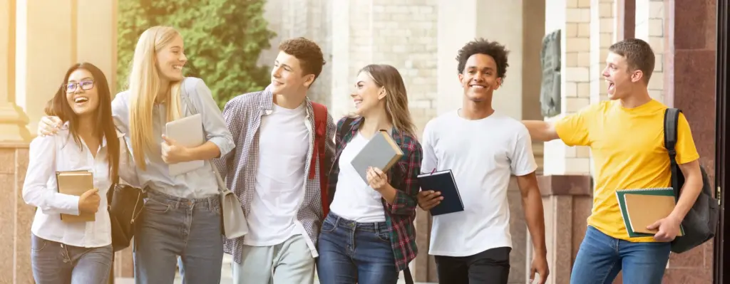 Eine Gruppe junger Auszubildenden läuft lachend über den Schulflur