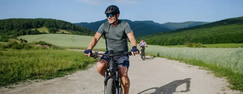 Ein sportlicher älterer Herr fährt mit seinem Mountainbike durch die Berge