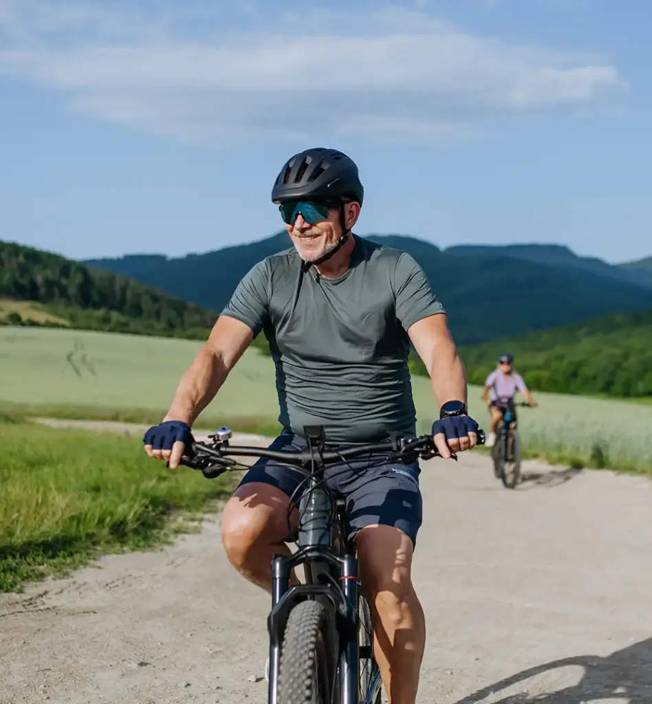 Ein sportlicher älterer Herr fährt mit seinem Mountainbike durch die Berge